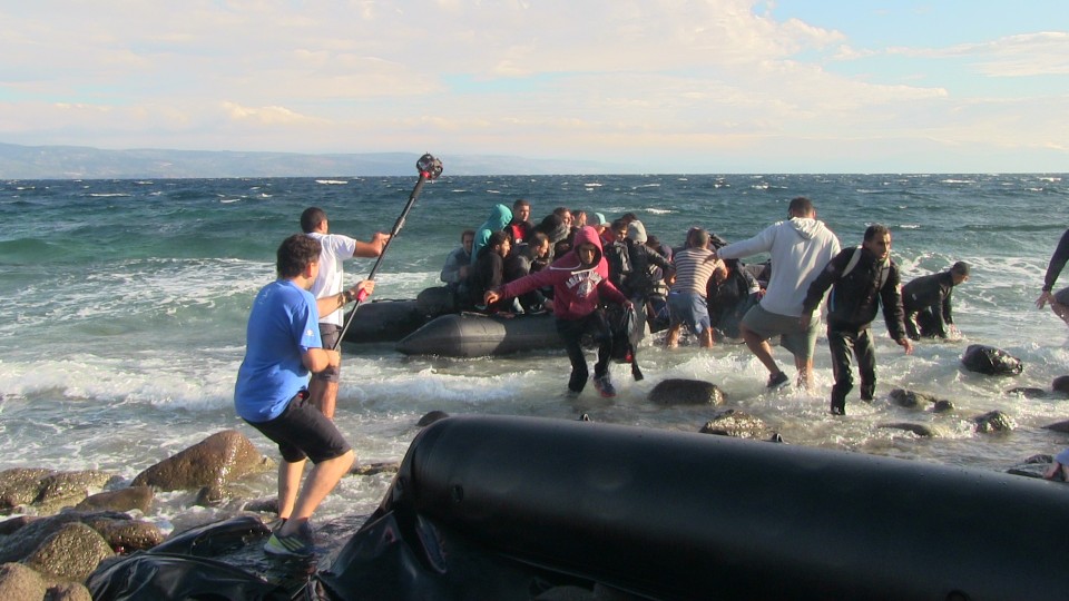 De vluchtelingen klauteren de rubberboot uit terwijl de GoPro-camera's draaien. Foto: Scopic.